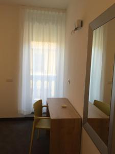 Zimmer mit einem Tisch, einem Spiegel und einem Fenster in der Unterkunft R&B La Calzoleria in Mori