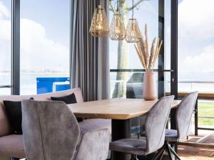 a dining room with a wooden table and chairs at Unique Houseboat on and around the Sneekermeer in Offingawier