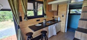 a kitchen in a tiny house with a sink and stools at Tiny Badacsony in Badacsonytomaj