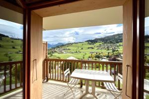 a balcony with a table and chairs and a view at Les Cimes Blanches in Combloux
