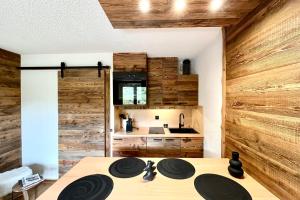 a kitchen with wooden walls and a wooden table at Les Cimes Blanches in Combloux