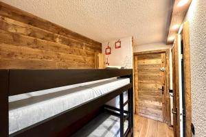 a bunk bed in a room with a wooden wall at Les Cimes Blanches in Combloux