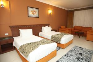 a hotel room with two beds and a couch at Grand Pyramids Hotel in Cairo +38 photos