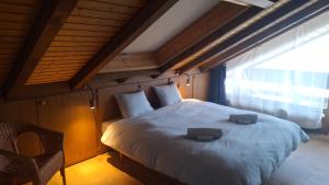 a bedroom with a large white bed with a window at Charming apartment with great view in Ovronnaz