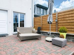 a patio with two chairs and an umbrella at Great holiday home in Bastogne with sauna in Le Parque
