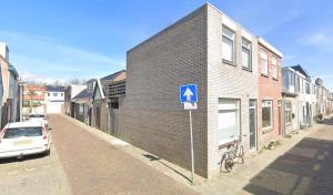 un edificio con una señal azul en el lateral de una calle en Casa Bron, en Den Helder