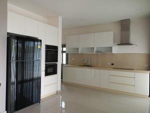 a kitchen with white cabinets and a black appliance at Anchan Gardens Pool Villa 23 in Hua Hin