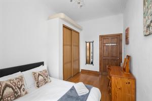 a bedroom with a bed and a wooden table at Beach Walk Apartment in Broughty Ferry