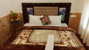 um quarto com uma cama grande com cabeceira de madeira em Om parvati em Kasol