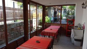 two red tables sitting on the outside of a restaurant at Къщи "И пак дойдох" in Tryavna