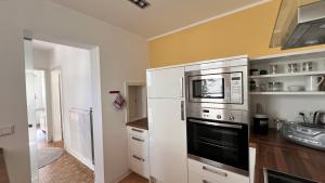 a kitchen with a refrigerator and a microwave at Ferienwohnung mit Garten am Wald in Barsinghausen +15 photos