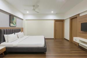 a bedroom with a bed and a flat screen tv at The Sky Imperial Welcome, Somnath in Somnath
