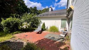 a patio with two chairs and a bench in a yard at Ferienwohnung mit Garten am Wald in Barsinghausen