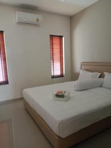 a white bedroom with a bed with a box on it at Anchan Gardens Pool Villa 23 in Hua Hin +33 photos