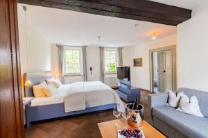 a large bedroom with a bed and a couch at Romantik Hotel Meisenheimer Hof in Meisenheim