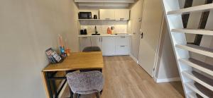 a small kitchen with a wooden table and chairs at Bulbs & Beach in Noordwijk