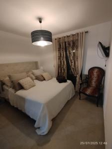 a bedroom with a large white bed and a chair at VILLA entre mer, montagnes, étangs et rivières in Ventiseri