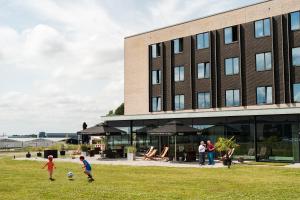 un grupo de personas jugando al fútbol delante de un edificio en Airport Hotel, Billund, en Billund