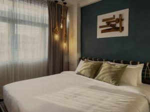 a bedroom with a large white bed and a window at Belivin'98 Sense of Pier Sathorn Residence in Bangkok