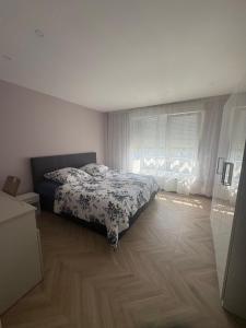 a bedroom with a bed with a floral bedspread at Moderne Appartement Strasbourg in Strasbourg