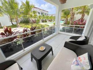 a living room with a balcony with a view of the ocean at Estrella Dominicus Apartamento - Bayahibe in Bayahibe