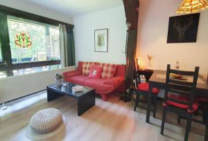 a living room with a red couch and a table at Begonie in Siegsdorf