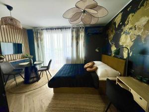 プウォツクにあるTravel Płock Apartamentのベッドルーム1室(大型ベッド1台、テーブル、椅子付)