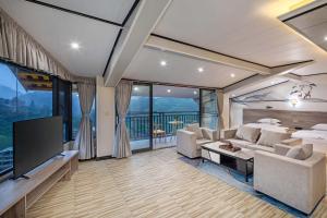 a living room with a couch and a tv at Bishui Jin Guesthouse (Longsheng Longji Rice Terraces Store) in Heping +34 photos