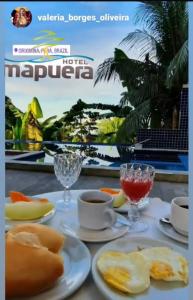 a table topped with plates of food and drinks at Hotel Mapuera in Oriximiná