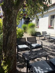 a group of benches sitting next to a tree at Rezidence U Kamenného mostu in Písek