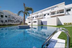 a swimming pool in front of a building at Casa Mia in Torrevieja