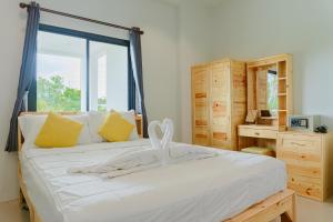 a bedroom with a white bed with a window at Phanomrung Hostel & Linn Chan Cafe พนมรุ้ง โฮส์เทล แอนด์ ลิณณ์จัง คาเฟ่ in Buriram +107 photos