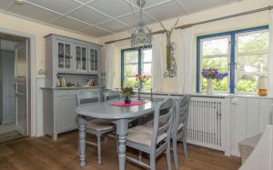 Una cocina con mesa y sillas y ventanas. en Luisenhof, en Süderhöft