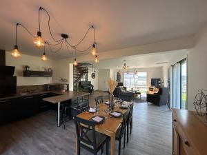 a dining room and living room with a table and chairs at Maison de l'écluse in Arzal
