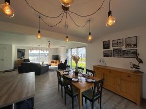 a dining room and living room with a table and chairs at Maison de l'écluse in Arzal