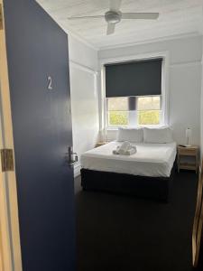 a bedroom with a white bed and a window at The Boatrowers Hotel in Stockton