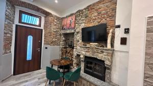a living room with a stone fireplace and a television at Casa Area in Somma Lombardo