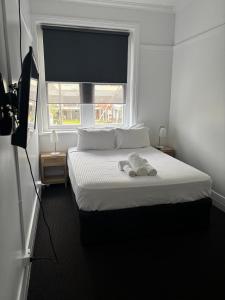 a bedroom with a bed with two towels on it at The Boatrowers Hotel in Stockton