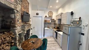 a kitchen with a wooden table and a stone wall at Casa Area in Somma Lombardo