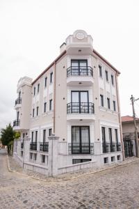 ein weißes Gebäude mit Balkonen an der Seite in der Unterkunft Vila Alko cozy studio apartment -1B in Korçë