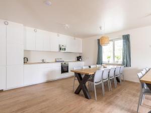 a kitchen and dining room with a wooden table and chairs at Lovely apartment on Ameland near Nes in Nes