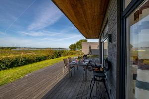 una terraza de madera con mesa y sillas en una casa en Auszeit, en Gelting