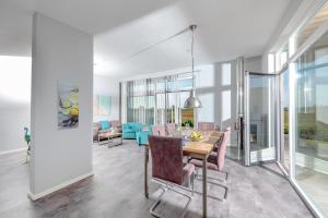 Un comedor y una sala de estar con mesa y sillas. en Auszeit, en Gelting 11 fotos más