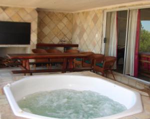 a bath tub filled with water in a living room at Shirleys Place in Brackenfell +5 photos