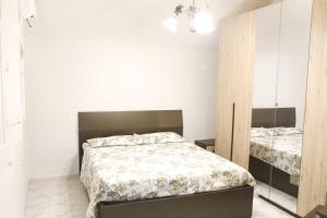 een slaapkamer met een bed en een spiegel bij Corte Cosi&Mia Centro storico in Gallipoli