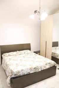 een slaapkamer met een bed en een kroonluchter bij Corte Cosi&Mia Centro storico in Gallipoli