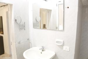 een witte badkamer met een wastafel en een spiegel bij Corte Cosi&Mia Centro storico in Gallipoli