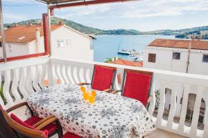 a table on a balcony with a view of the water at Hana Home - Apartments Tisno in Tisno