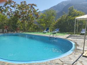 a large swimming pool with a table and two chairs at Camping Trevélez in Trevélez