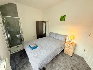 a small bedroom with a bed and a shower at BIG double room Attached Shower near to city center in Nottingham